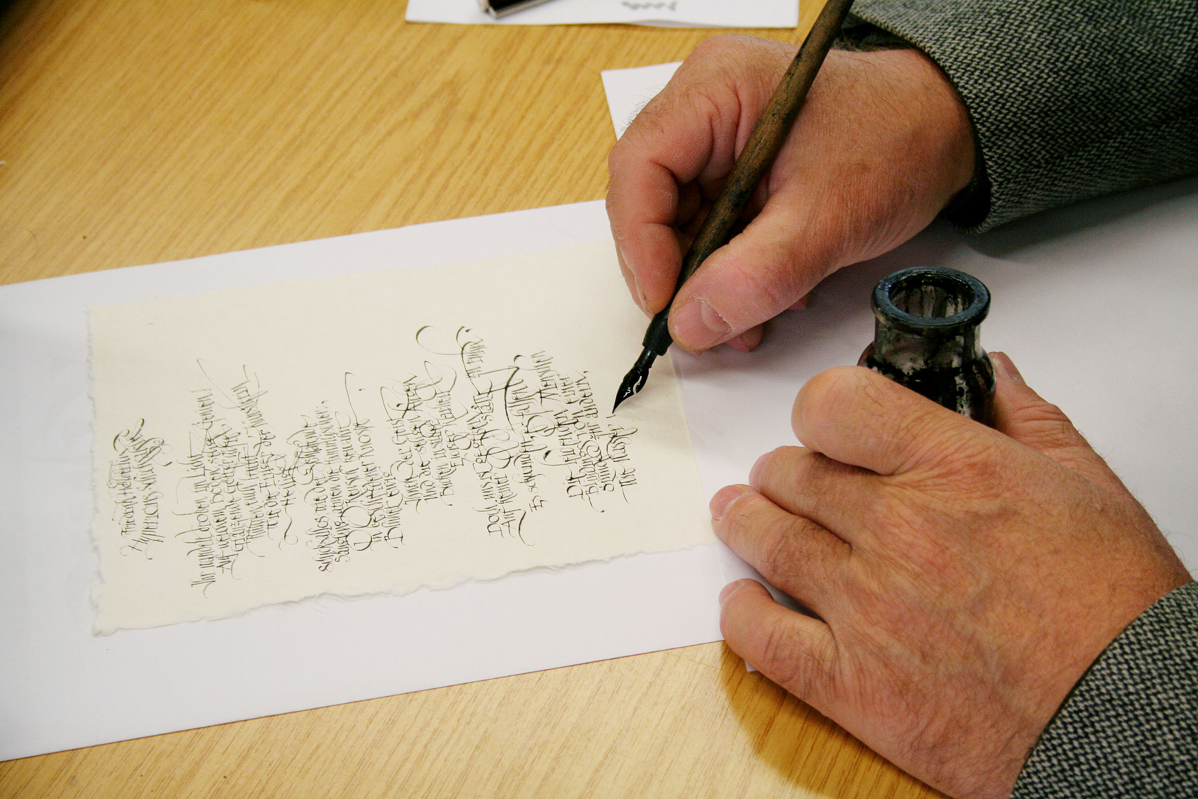 Hand beim Schreiben mit Feder und Tinte
