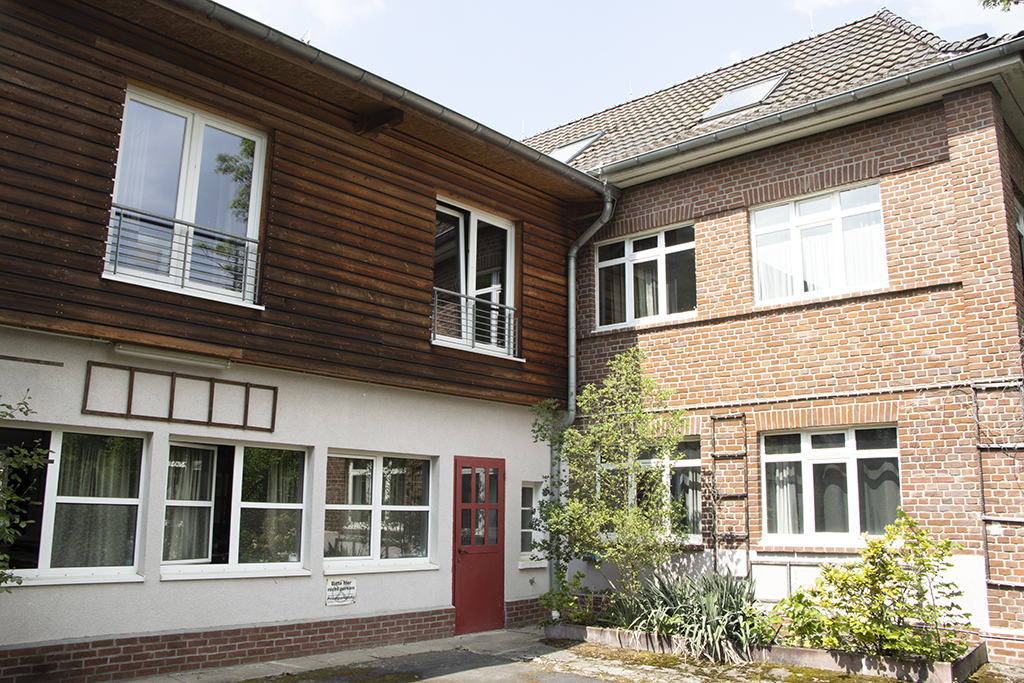 Begrünter Innenhof und roter Eingang des RSIAD in Hennef